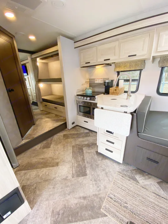 RV rental: Modern kitchen with stove, sink, and microwave, plus cozy bunk beds for family comfort and adventure.. Forest River Forester 2021
