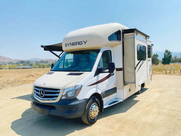 White Mercedes-Benz Synergy Class C motorhome, an ideal RV rental, parked on a dirt lot with awnings extended.. Thor Motor Coach Other 2016