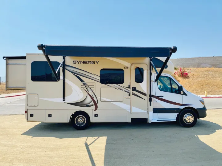 This beige Thor Synergy Class C RV with an extended awning and slide-out is ready for an exciting rv rental adventure.. Thor Motor Coach Other 2016