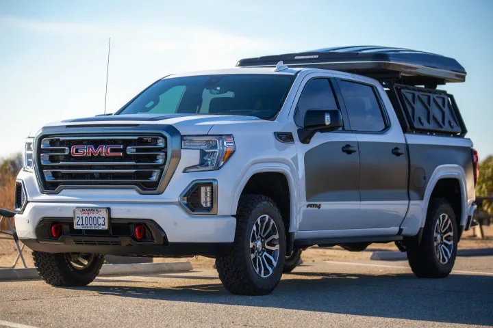 Overlanding-ready white GMC Sierra AT4 truck with rooftop tent. Explore via this versatile RV rental.. Other Other 2021