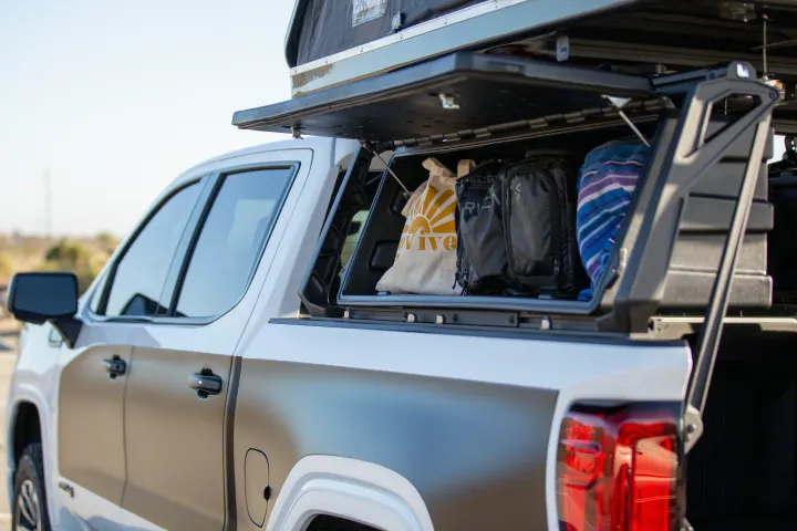 White & grey pickup truck with open bed storage, bags, & a rooftop tent. Ready for your next rv rental adventure!. Other Other 2021