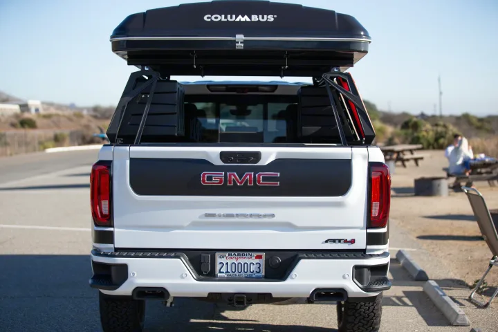 Rear view of a white GMC Sierra AT4 pickup truck with a rooftop tent. An excellent rv rental alternative for camping and outdoor travel.. Other Other 2021