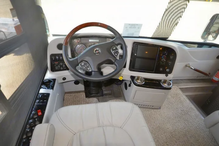 An RV rental's driver's cockpit: detailed view of the steering wheel, dashboard, and various controls.. Entegra Coach Anthem 44B 2017
