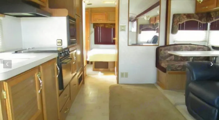 Explore this RV rental's spacious interior: full kitchen, inviting living area with dining and seating, plus a comfortable bedroom.. Fleetwood Jamboree Sport 1999