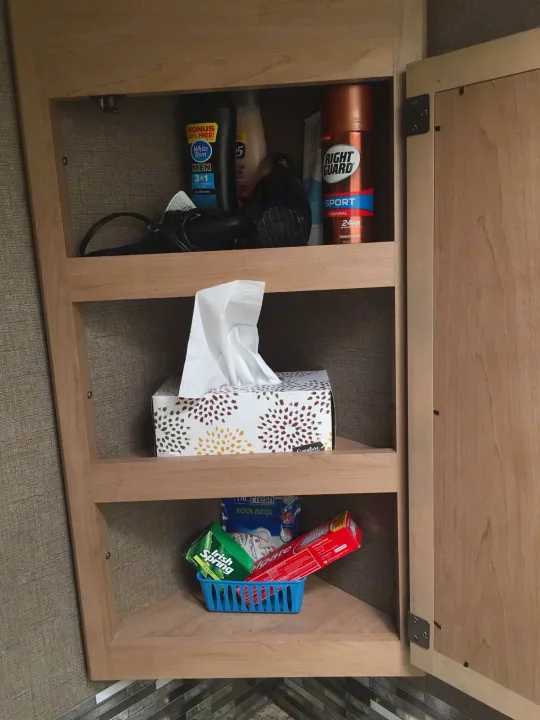 This RV rental cabinet is organized with personal care items: shampoo, deodorant, tissues, soap, and toothpaste.. Thor Freedom Elite 2018