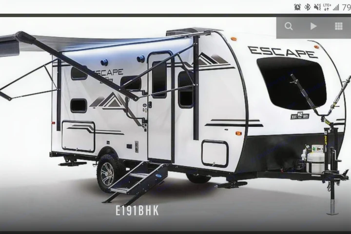 White Escape E191BHK travel trailer RV rental, featuring an extended awning and entry steps, ready for adventure.. K-Z Manufacturing Escape 191bhk 2021