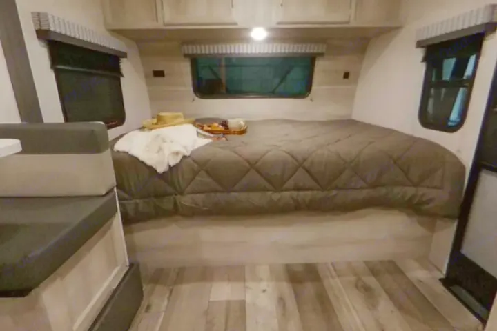 This cozy RV rental interior features a comfy bed, windows, and seating, ready for your next road trip adventure.. K-Z ? Escape 2021