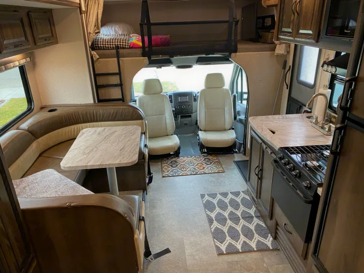 Cozy RV rental interior: view of kitchen, dinette, and cab-over bunk.. Coachmen Prism 2019