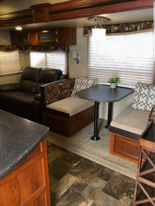 Cozy RV rental interior with dinette, couch, and kitchen counter. Perfect for travel.. Forest River Crusader 2015