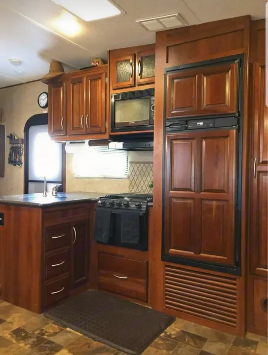 Spacious RV rental kitchen with wood cabinets, microwave, stove, & fridge. Perfect for your next adventure.. Forest River Crusader 2015