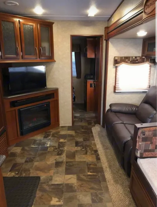 Spacious rv rental living area with entertainment center, fireplace, and comfortable seating. Ideal for your next adventure!. Forest River Crusader 2015