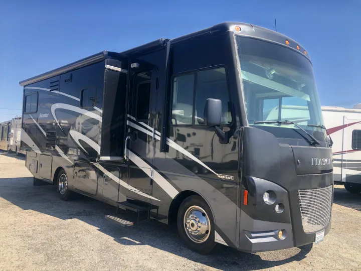 Spacious black Winnebago Itasca Sunstar RV rental, featuring an open door and steps on a clear day.. Itasca Sunstar 2015