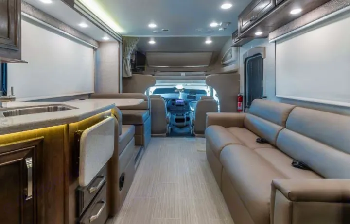Spacious RV rental interior: kitchen, dinette, and comfortable living area with sofa, perfect for road trips.. Entegra Coach Esteem 2021