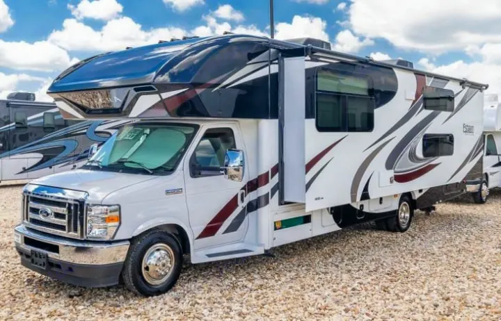 Modern white Class C RV rental, featuring sleek dark and brown graphics, parked on gravel. Perfect for a motorhome adventure!. Entegra Coach Esteem 2021