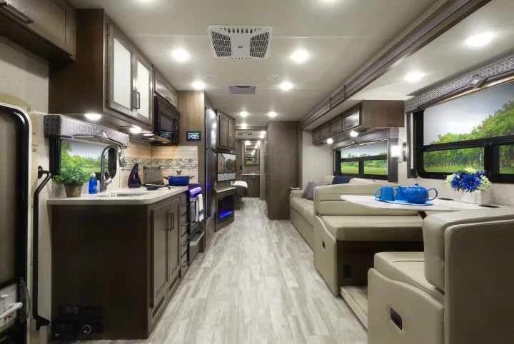 Inside a bright RV rental: features a full kitchen, comfortable living area with dinette, and ample space for travel.. Thor Motor Coach Hurricane 2021