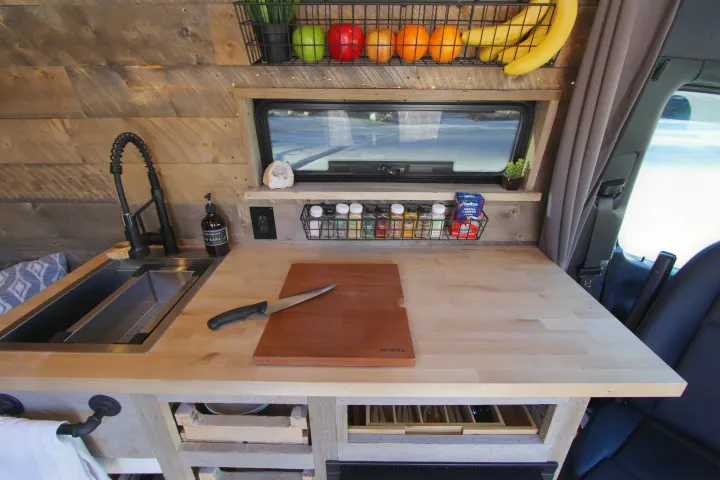Custom RV rental kitchen with sink, butcher block counters, and smart storage. Perfect for your next adventure!. Mercedes-Benz Sprinter 419 LWB High Roof 2020