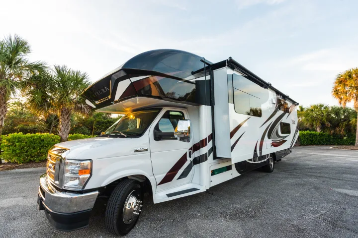 White Entegra Class C RV rental parked among palm trees. Perfect for your next road trip adventure.. Entegra Coach Esteem 31F 2021