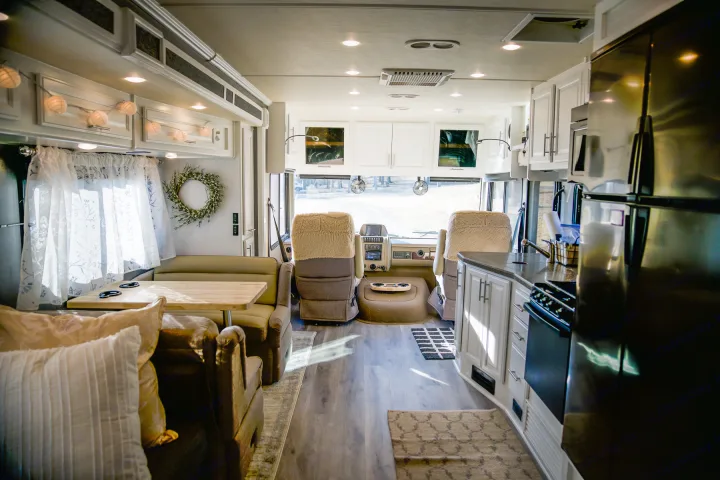 Explore the spacious interior of this comfortable rv rental, featuring a full kitchen, dining nook, and driver's area.. Fleetwood Bounder 2015