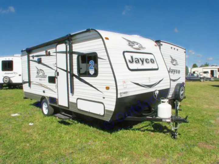 White Jayco travel trailer on green grass, under blue sky. This RV rental is ready for your next adventure.. Jayco Baja 2016