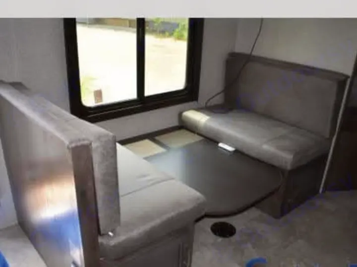 RV rental interior: Comfortable dinette with grey upholstered benches & dark table by the window. Perfect for meals on the go.. Jayco Jay Flight 2021