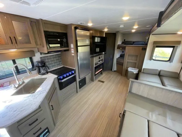 Spacious RV rental interior featuring a well-equipped kitchen, comfortable bunk beds, and a cozy living area.. Keystone Hideout 2021