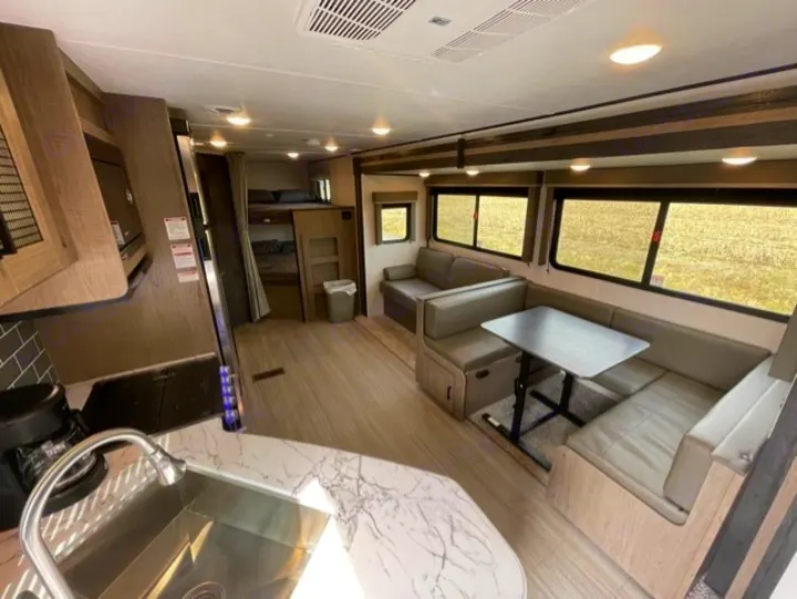 This rv rental offers a well-equipped kitchen, U-shaped dinette, sofa, and bunk beds, all in a bright, spacious interior.. Keystone Hideout 2021