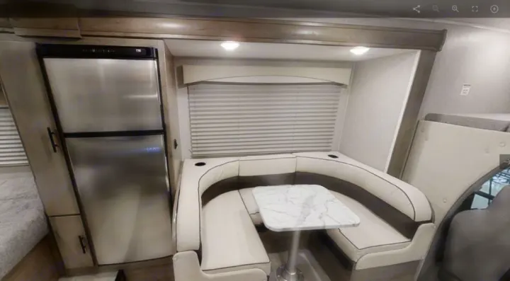 Explore this RV rental's inviting interior! Features a compact kitchen with fridge, cozy dinette, and comfortable sleeping space.. Coachmen Freelander 2022