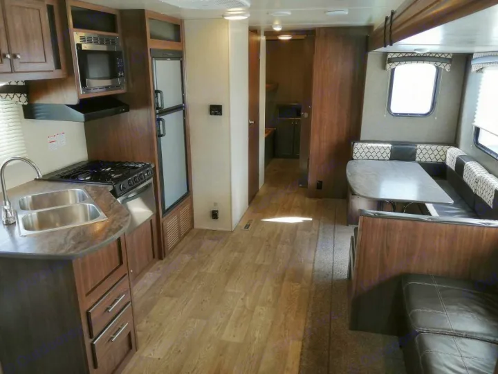 Step inside this RV rental! View of the living space with a kitchen (sink, stove, microwave, fridge) and comfortable dining area.. Heartland Prowler Lynx 2018