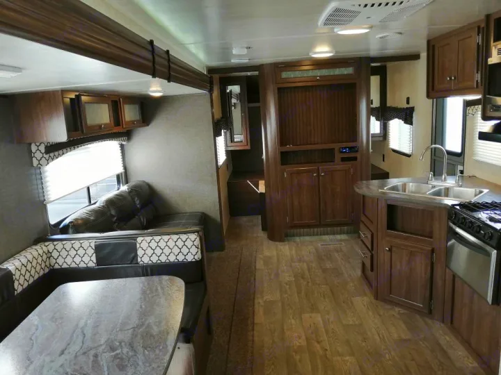 Step inside this RV rental: kitchen with sink, cozy dinette, and living area with sofa.. Heartland Prowler Lynx 2018