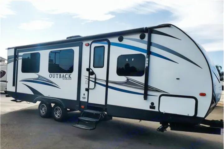Modern white Outback travel trailer RV rental with blue accents, steps extended, ready for your next adventure.. Keystone Outback 2019