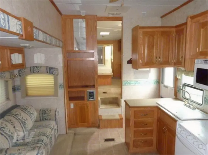 Explore this RV rental interior with a welcoming living area, fully equipped kitchen, and steps to the upper level.. Other Other 2005
