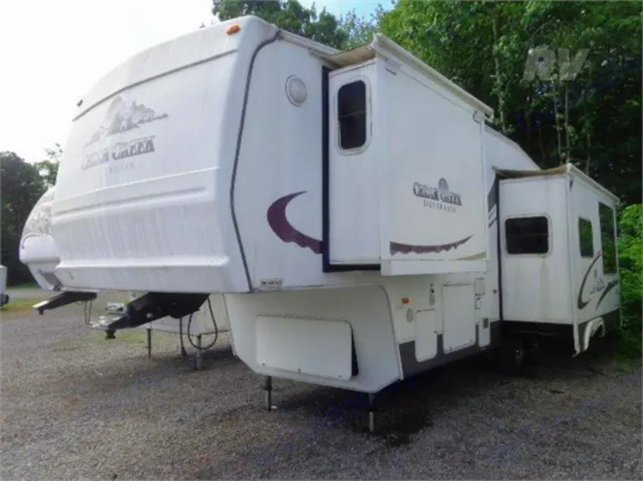 Spacious white Silver Creek fifth-wheel RV with extended slide-outs parked on gravel, ideal for your next RV rental.. Other Other 2005