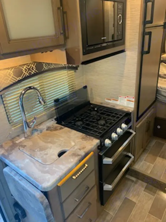 3 burner stove, microwave, sink, lift-up counter expansion, refrigerator & freezer. Thor Motor Coach Chateau 2021