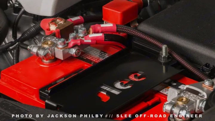 Close-up of a powerful red vehicle battery and custom terminals. Essential for a reliable rv rental or off-road trip.. Toyota Land Cruiser 200 Series 2021