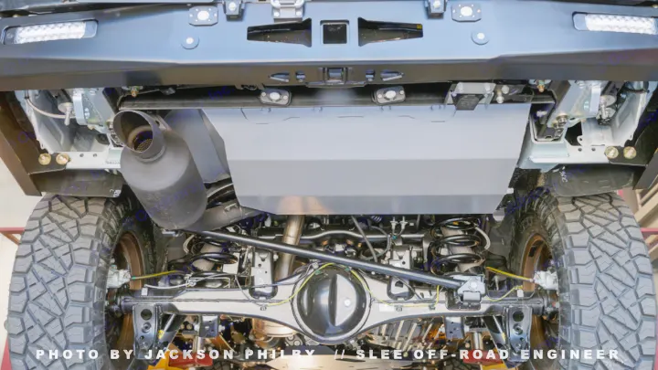 Undercarriage view of an off-road ready vehicle, ideal for adventure or an RV rental alternative. Features robust suspension and skid plate.. Toyota Land Cruiser 200 Series 2021