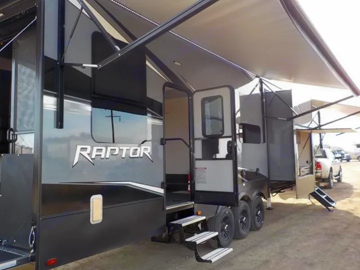 Large multi-axle Raptor fifth-wheel RV rental with an open door, extended steps, and wide awning.. Keystone Raptor 2020