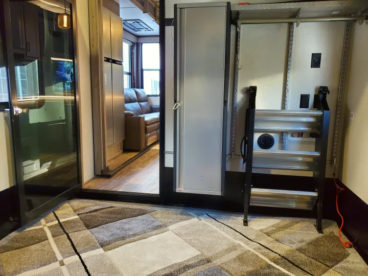 RV rental interior showing a sophisticated living area on left, connected to a versatile rear utility/storage space on right.. Keystone Raptor 2020
