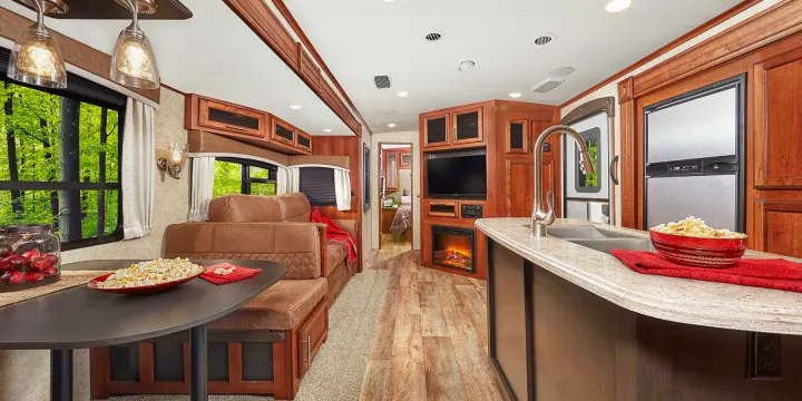 Modern RV rental interior features a spacious living area, kitchen, and fireplace, offering a cozy retreat amidst nature.. Jayco Eagle HT 2018