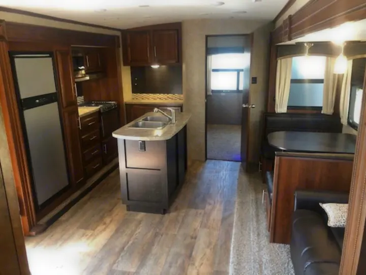 Spacious RV rental interior featuring a full kitchen with island sink, dinette, and comfortable living area.. Jayco Eagle HT 2018