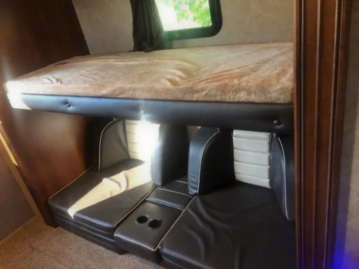 Cozy RV rental: Bunk bed with fluffy mattress over dark leatherette dinette seating with cupholders.. Jayco Eagle HT 2018