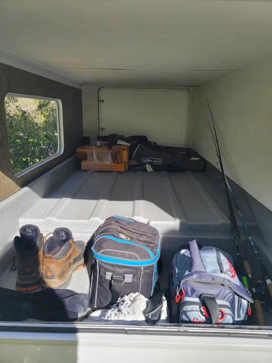 Inside an RV rental's pass-through storage: fishing rods, hiking boots, and camping gear neatly stowed.. Forest River Sunseeker 2019