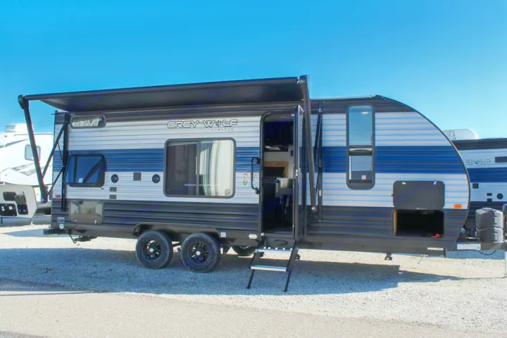 This Grey Wolf travel trailer RV with an extended awning and open door is ready for your next rv rental adventure.. Forest River Cherokee Grey Wolf 2021