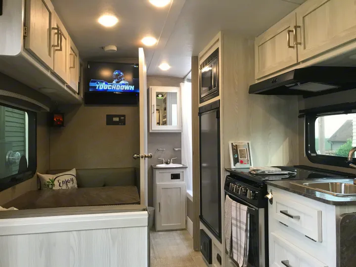 Experience compact living in this modern rv rental, featuring a dinette, TV, kitchen, and bathroom. Perfect for travel!. Forest River Rockwood 2021