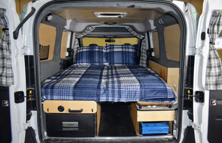 This RV rental offers a cozy bed, Dometic fridge, and portable stove, perfect for camping and mobile living.. Dodge Promaster City 2019