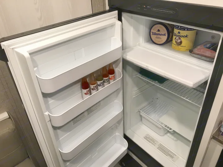 Inside an RV rental fridge: Tillamook ice cream, ground meat, and hot sauce on door shelves. Ready for your adventure!. Forest River Rockwood 2021