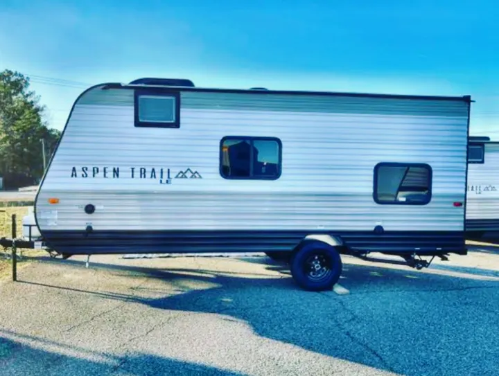 Sleek Aspen Trail LE travel trailer available for rv rental, parked outdoors. Perfect for your next road trip!. Aspen Other 2021