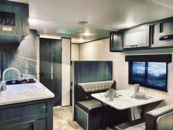 Modern RV rental interior with a kitchen, sink, and dinette seating. Ideal for comfortable travel.. Aspen Other 2021