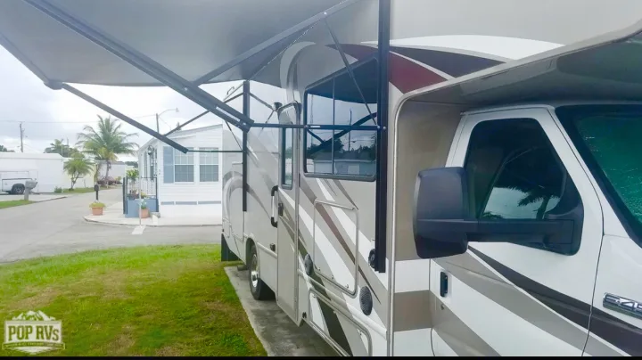 This Class C RV rental with an extended awning is parked in a sunny resort, perfect for your next vacation.. Other Four Winds 2016