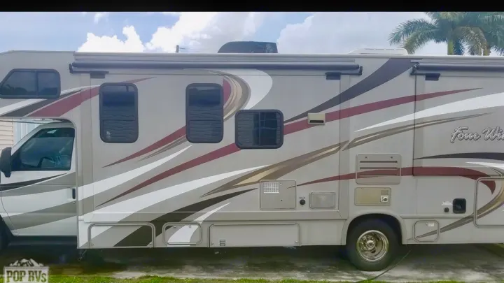 Light tan Class C RV rental, featuring burgundy & white stripes, ready for travel.. Other Four Winds 2016