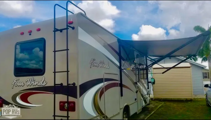 RV rental: A Four Winds motorhome with an extended awning. Ladder visible at the rear. Great for outdoor travel.. Other Four Winds 2016